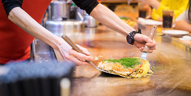 Cooking Japanese pizza on hot counter stock photo