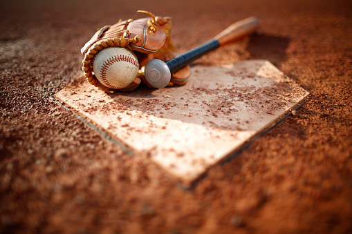 High angle view of old baseball glove, ball and bat on field for baseball game outdoors