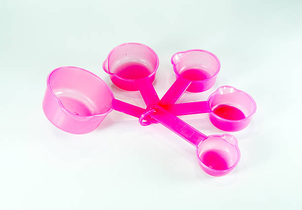 istock Pink measuring plastic spoons isolated on white background 522487929