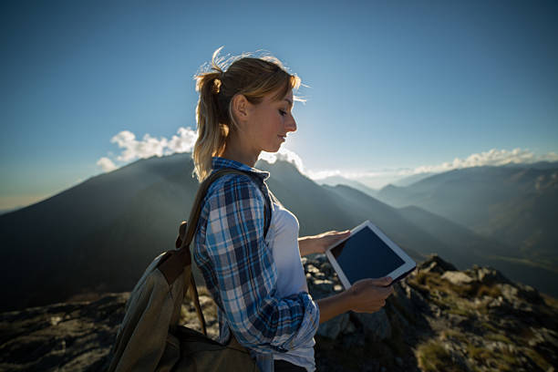 istock Young woman at mountain peak using tablet 522489853
