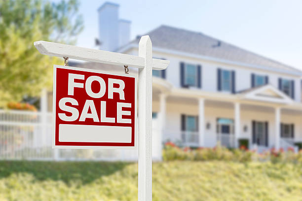 Home For Sale Sign in Front of New House Home For Sale Real Estate Sign in Front of Beautiful New House. house for sale sign stock pictures, royalty-free photos & images