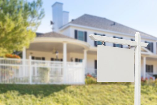 Blank Real Estate Sign in Front of Beautiful New House.