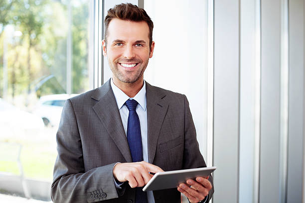 istock Happy businessman standing with laptop in office 522511227