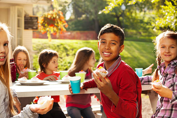 istock Central Asian boy holds cupcake, with his friends 522511295