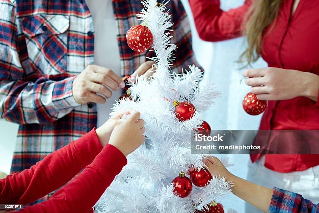 hands of family decorating New Year tree close-up photo of hands of family decorating New Year tree 25-29 Years Stock Photo