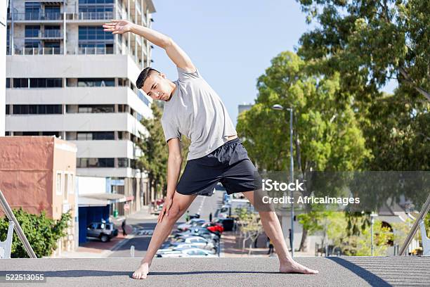 African Guy Doing Yoga On The City Bridge Stock Photo - Download Image Now - Active Lifestyle, Balance, Bending