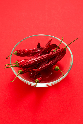 Glass bowl filled with dry chili peppers.