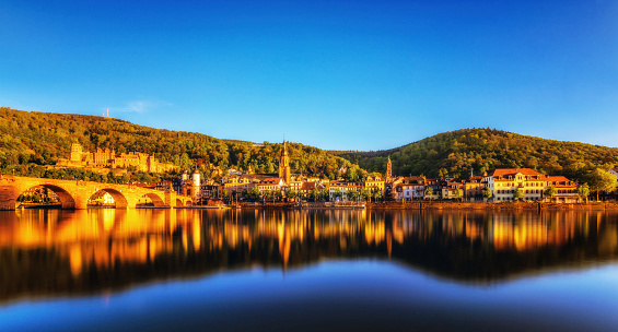 Panoramic view on Heidelberg reflecting in the river Nekar at sunset.  