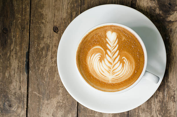 istock Latte art coffee on dark grained wood top view 522520403