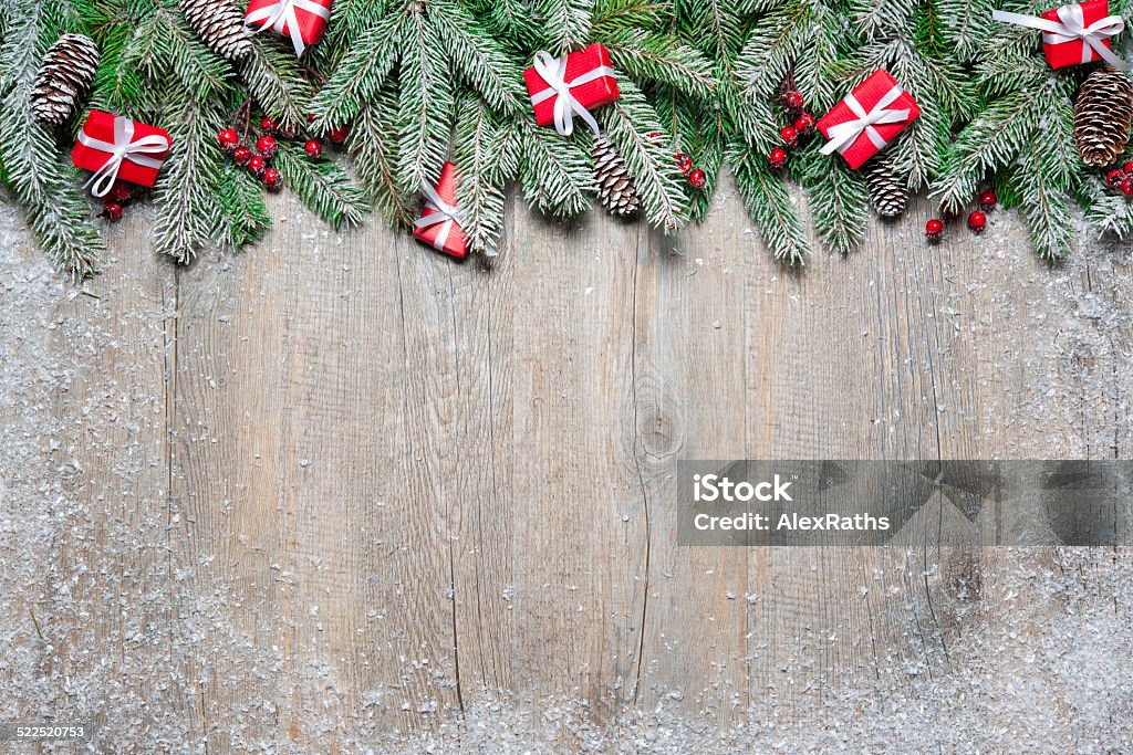 Christmas background Fir tree branches with christmas gift boxes on old wooden board Advent Stock Photo