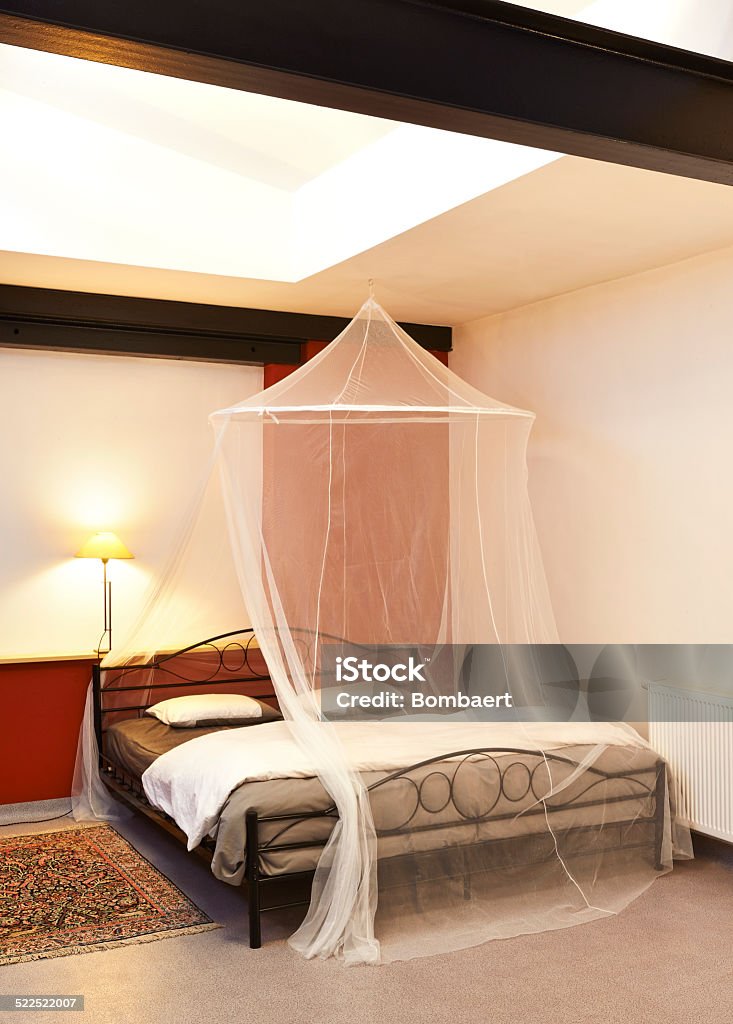 Cosi vintage bed with mosquito Net in a restored loft Architecture Stock Photo