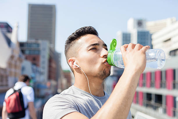istock athlete stops on the bridge to drink from his water 522523345