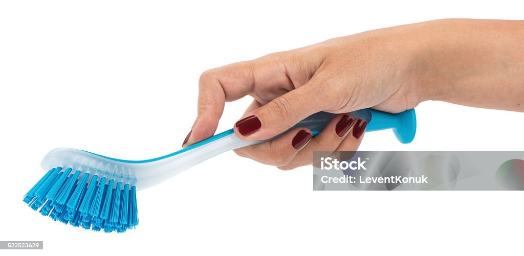 Dishwashing Brush on Hand Woman hand holding dishwashing brush isolated on white background. Blue Stock Photo
