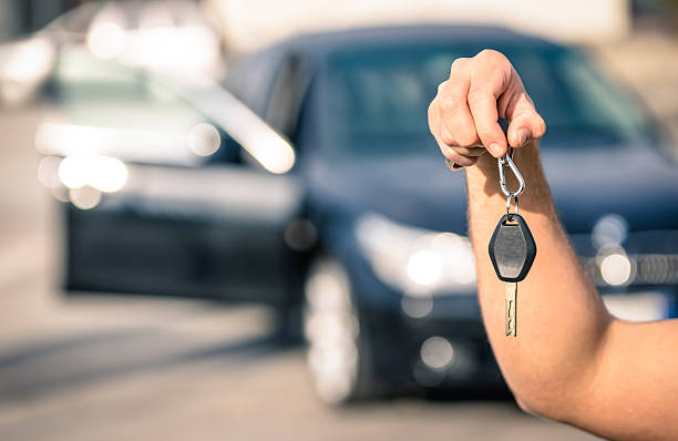 Man's hand holding modern car keys ready for rental stock photo
