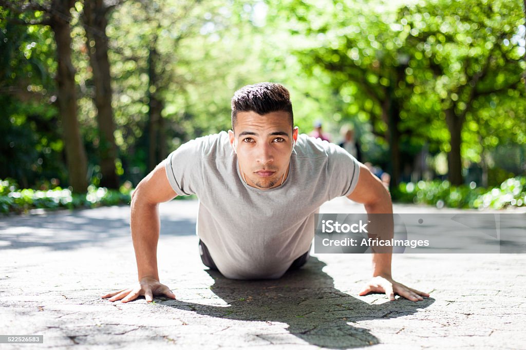 young man doing a push up in the city park young african athlete doing push ups in on the walk in the city park. cape town, western cape, south africa Active Lifestyle Stock Photo