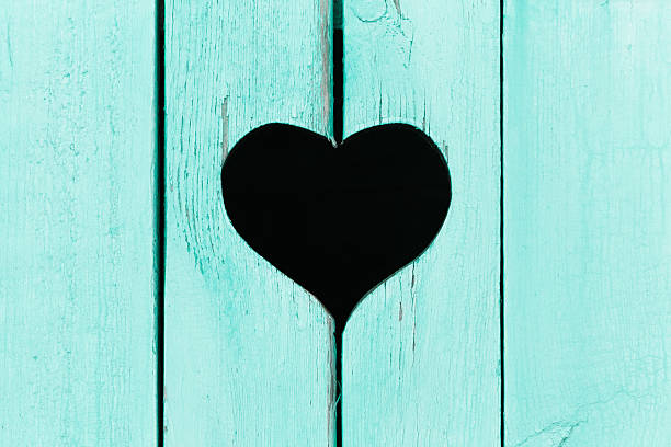 wooden background from old boards with a window in the shape of heart