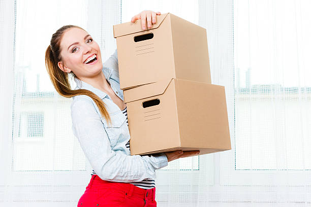 istock Happy woman moving into house carrying boxes. 522530838