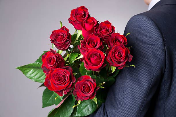 istock Man with bouquet of red roses on a gray background 522532462