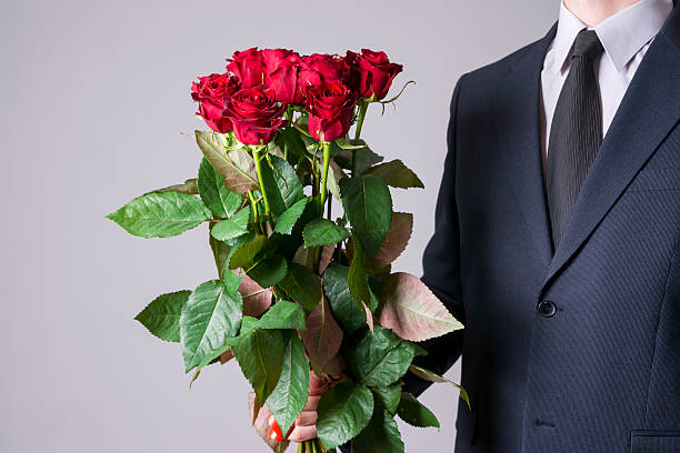 istock Man with bouquet of red roses on a gray background 522532550