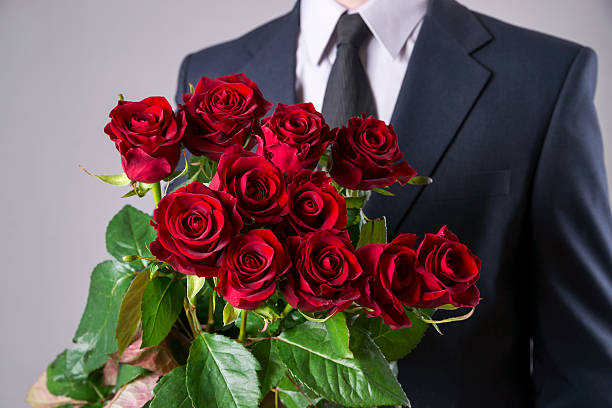 istock Man with bouquet of red roses on a gray background 522532792
