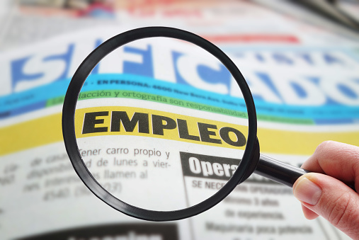 Spanish newspaper classified employment ( empleo ) section with magnifying glass