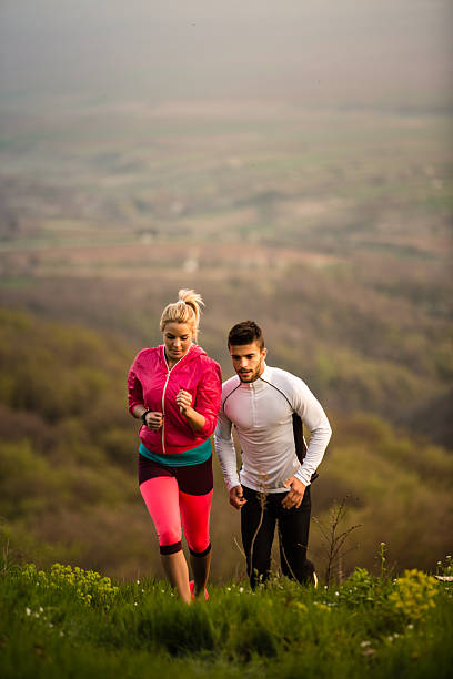 istock Couple runs along mountain field 522534018