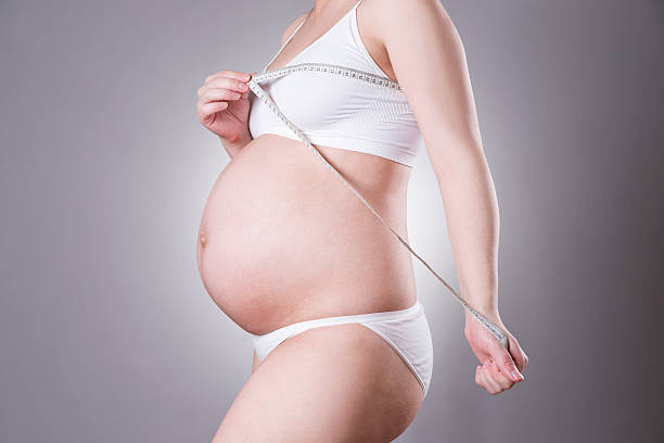ciąży i odżywianie-kobieta w ciąży z pomiaru taśmą - undernourishment zdjęcia i obrazy z banku zdjęć