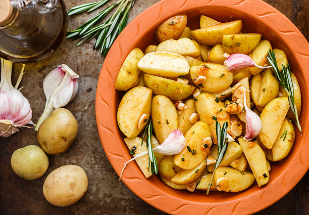 istock Sliced raw potatoes in a clay baking dish before baking 522534586
