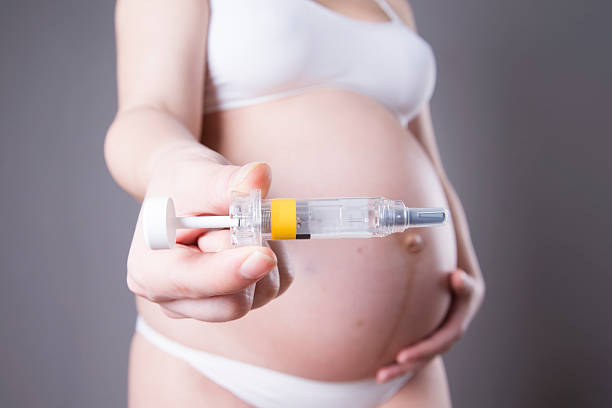 jeune femme enceinte faisant injection dans le ventre - frustration women threats disappointment photos et images de collection
