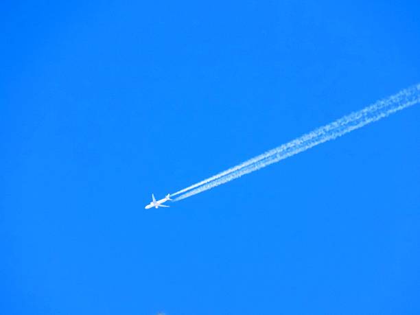 istock Airplane with chemtrails on blue sky 522536104