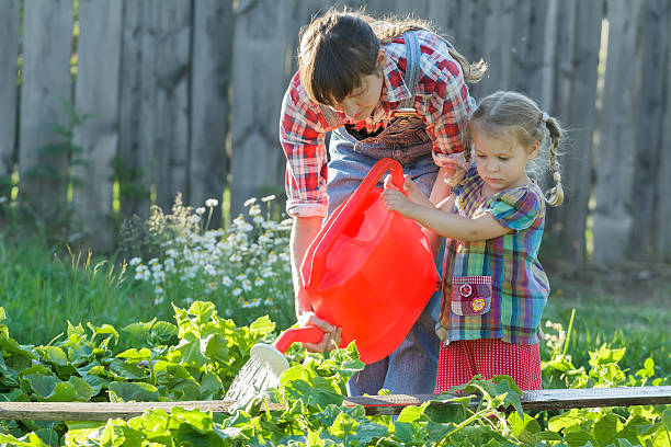Woman helping her daughter to pour cucumbers