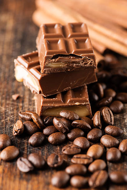 istock Chocolate candy bar and cofee beans on wooden table 522538669
