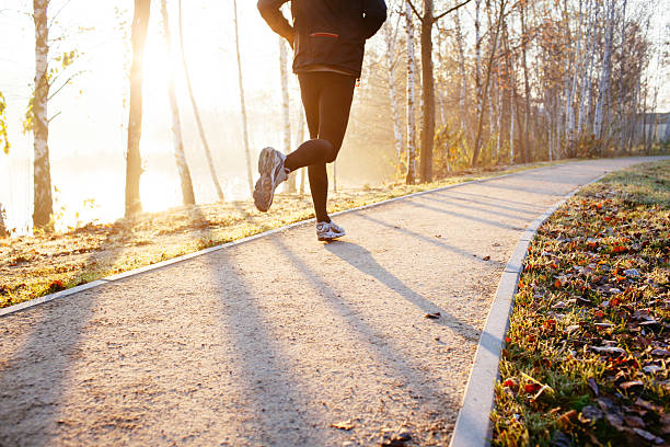 hombre corriendo en otoño durante el amanecer - atletismo en pista masculino fotografías e imágenes de stock