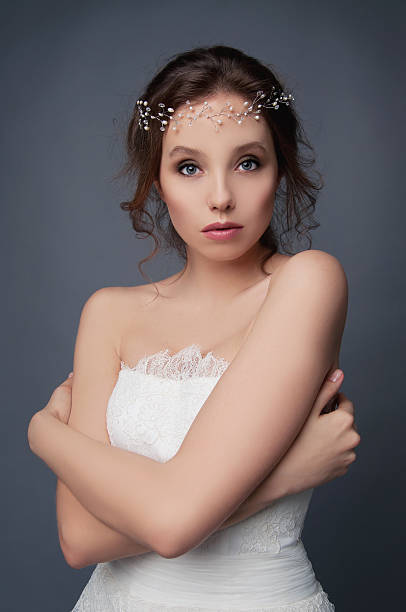istock Shy cute bride in white wedding dress and beaded headpiece 522541274
