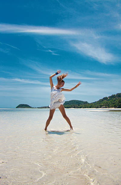 istock Young woman dancing in the sea 522542791
