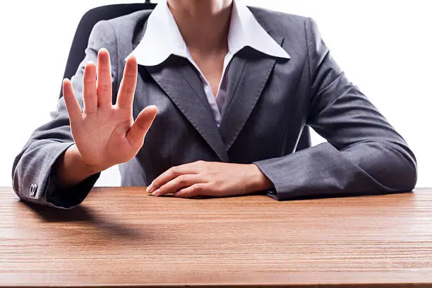 Businesswoman showing number five hand gesture at desk.