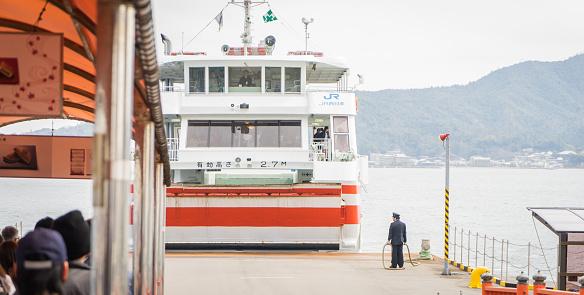 Hiroshima, Japan - March 16, 2016: Tourists are waiting to board the Miyajima island Ferry.