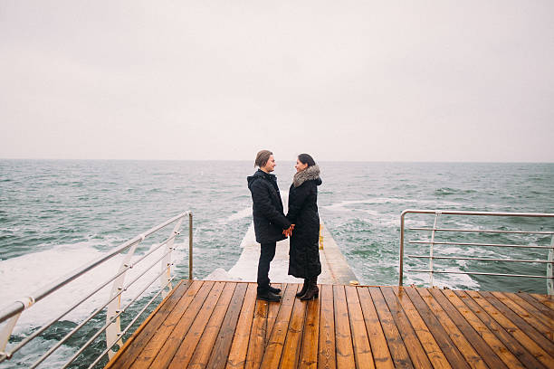 istock Romantic young couple on a pier looking away, back view 522543658