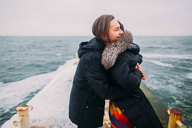 istock Beautiful young couple tenderly hugging on stoned pier during rainy 522544330