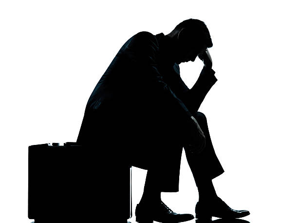 istock one business man sitting on suitcase tired despair silhouette 522544929