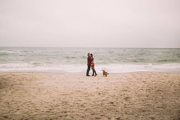 istock Pretty young romantic couple softly embraces on the winter beach 522546058