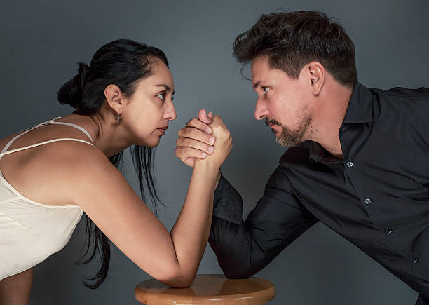 istock Couple Arm Wrestling Against Dark Background 522546314