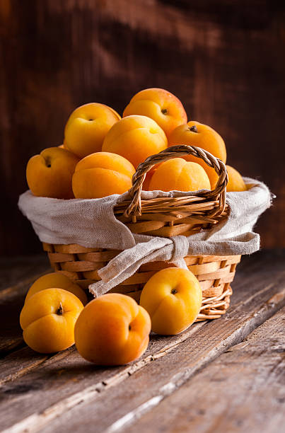 istock Apricots group in basket on wooden table 522546360