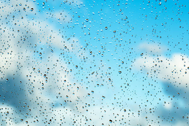 tipo lluvia, gotas de agua sobre una ventana contra el cielo azul - condensation drop water rain fotografías e imágenes de stock