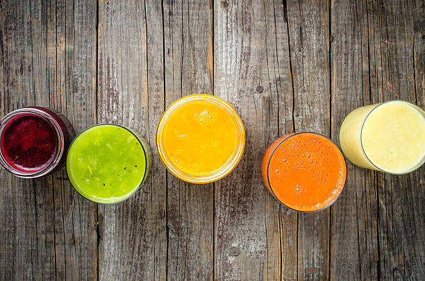 vasos de jugo fresco sobre una mesa de madera - juice vegetable fruit vegetable juice fotografías e imágenes de stock