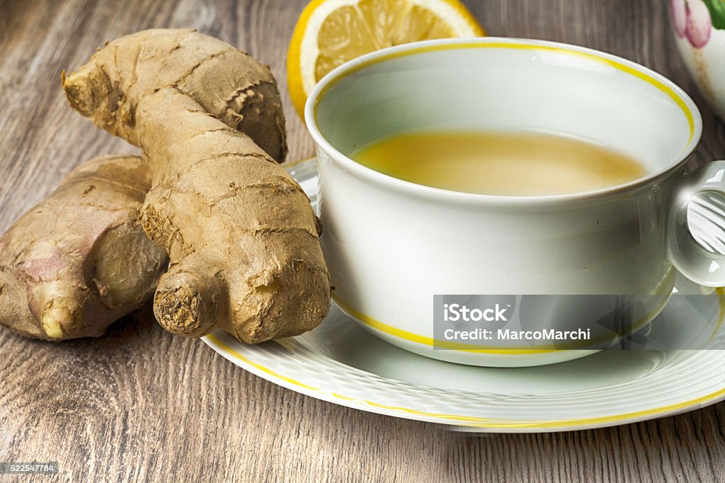 Ginger tea Ginger tea in a white cup on wooden background Alternative Medicine Stock Photo