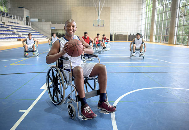 Handicap man playing basket Handicap man playing basket sitting on a wheelchair and looking at camera holding the ball athlete fails stock pictures, royalty-free photos & images