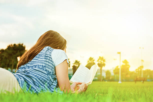 istock young and beautiful woman on the grass with a book 522561449