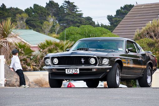 Christchurch,New Zealand - November 08, 2014: Car enthusiast driving a fully restored Ford Mustang Mach from 1969  in a classic car cavalcade the New Brighton  Parade. The car parade is held every year in Christchurch  New Zealand.