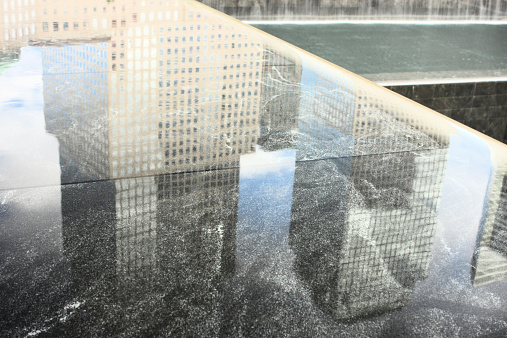 Building reflection in the September 11 Memorial reflecting pool at the foot of the new World Trade Center - abstract.  New York City, New York, 2014.